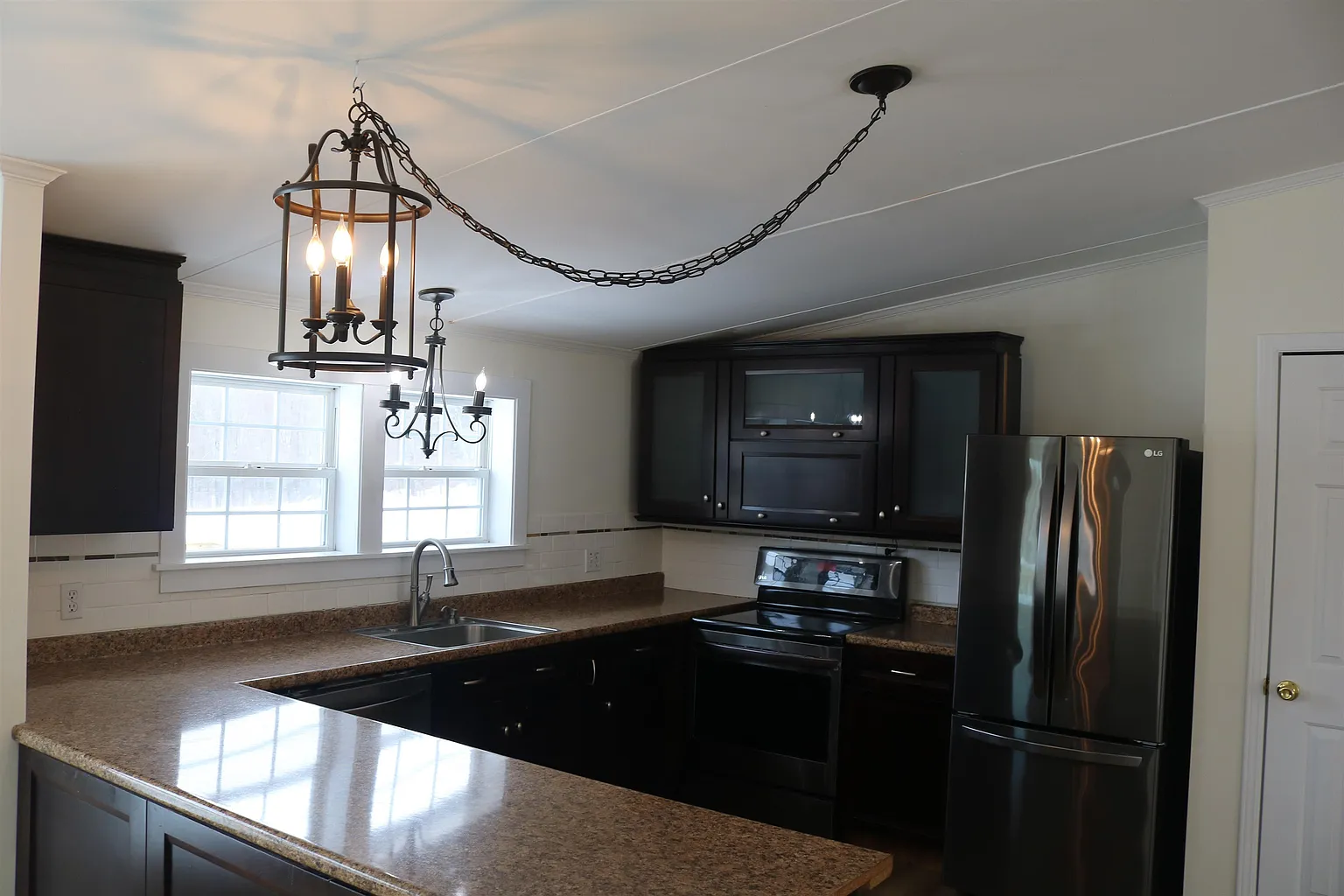 Kitchen with dark cabinetry and stainless appliances